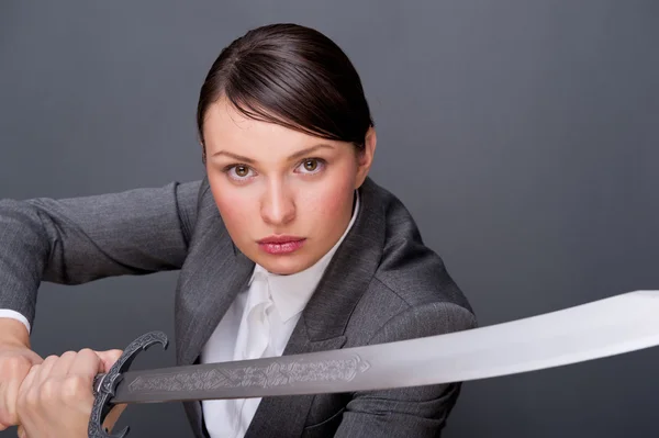 Affärskvinna som visar beslutsamhet medan du håller ett svärd — Stockfoto