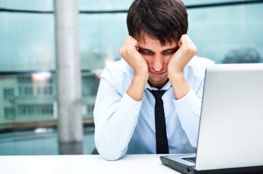 Tired businessman sleeping at his desk in the office with both arms on cheeks clipart