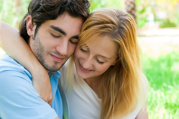 浪漫的年轻夫妇，一起坐在夏天公园拥抱和微笑 — 图库照片