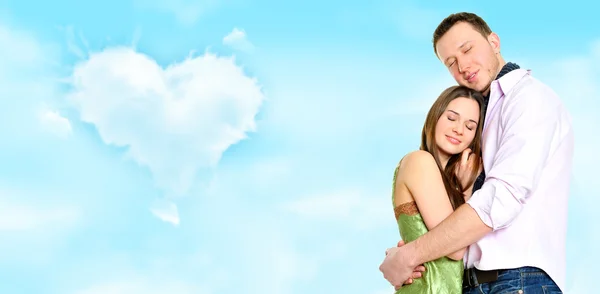 Portret młodej pary stojących razem. mnóstwo lato i chmury w kształcie serca grafiki — Zdjęcie stockowe