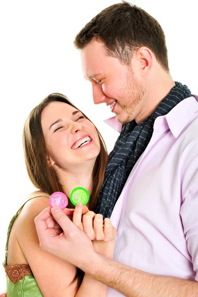 Retrato de jovem casal de pé juntos e abraçando e segurando preservativos. Conceito de sexo seguro. Isolado sobre fundo branco — Fotografia de Stock