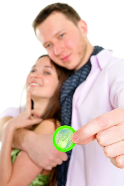 Ritratto di giovane coppia in piedi insieme e abbracciando e tenendo preservativi. Concetto di sesso sicuro. Isolato su sfondo bianco — Foto Stock
