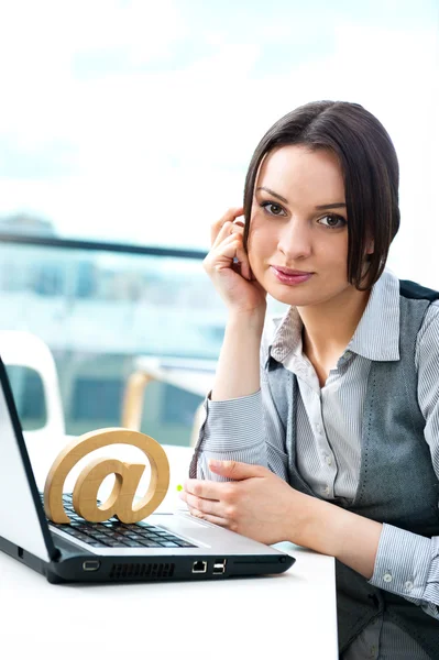Προσωπογραφία γυναίκας επιχειρήσεων χαρούμενος κάθεται στο γραφείο της με μια στο σύμβολο — Φωτογραφία Αρχείου
