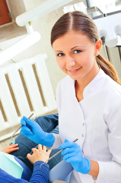 At dentists office young nurse checking patients mouth and cleaning — Stock Photo, Image
