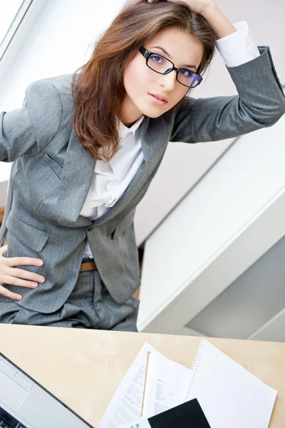 Güzel bir iş kadını ofisinde çalışırken çok meşgul ve biraz yorgun — Stok fotoğraf