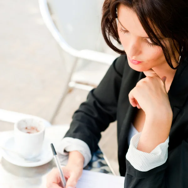 Nahaufnahme Porträt einer hübschen Frau, die im Café sitzt und Doc signiert — Stockfoto