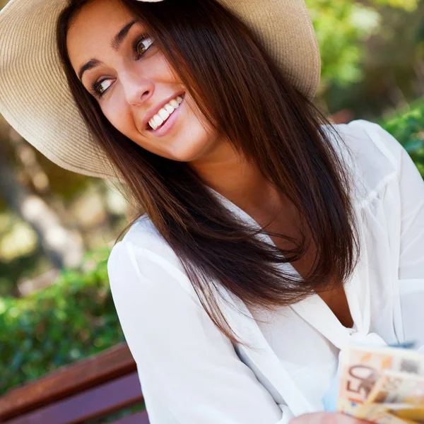 Porträt einer jungen hübschen Frau, die im Sommer oder Winter auf einer Bank sitzt — Stockfoto