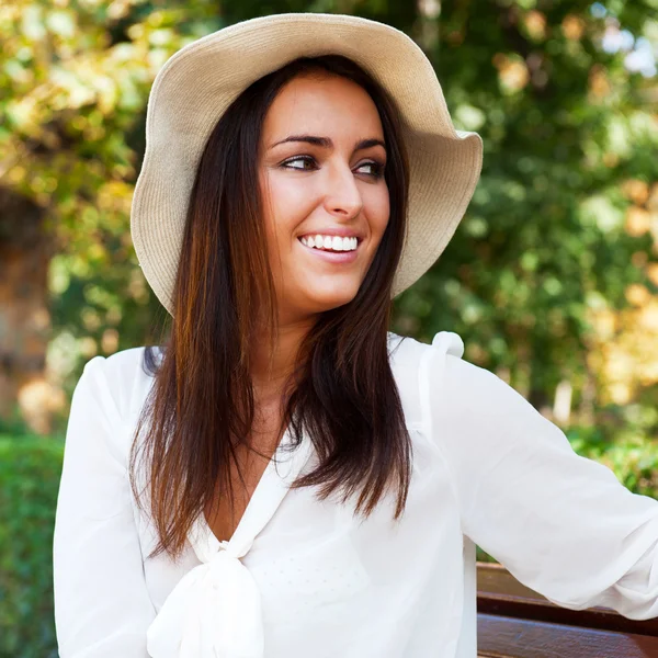 Porträt einer sexy jungen Frau, die im Sitzen in einem Park lächelt — Stockfoto