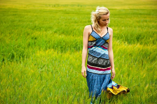 Candid carefree adorable woman in field with at summer sunset wearing bright colorful dress — Stock Photo, Image