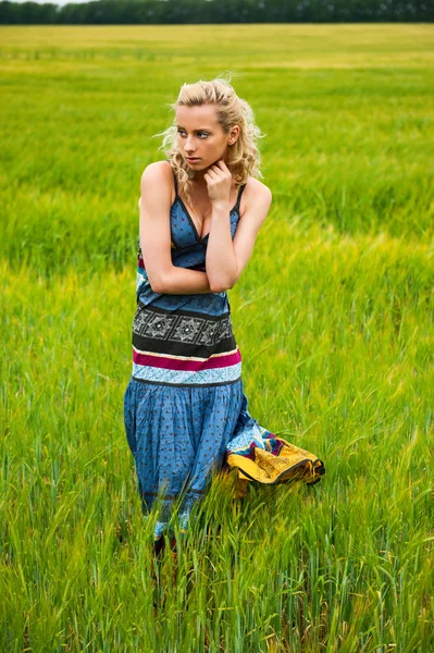 Mulher adorável despreocupado sincero no campo com no pôr do sol de verão vestindo vestido colorido brilhante — Fotografia de Stock