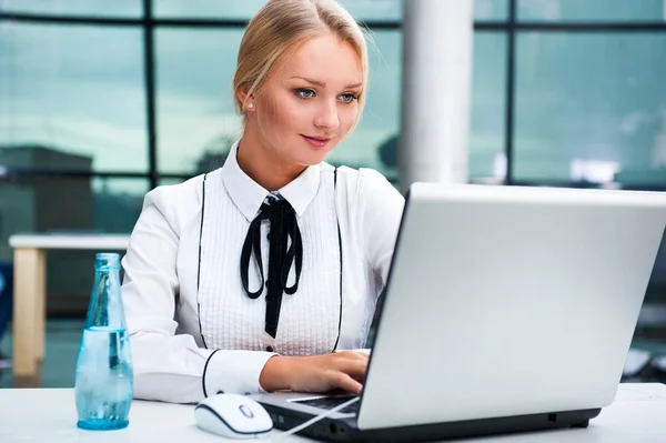Porträt einer schönen jungen Geschäftsfrau am Computer, die arbeitet. Hintergrund Büro. — Stockfoto