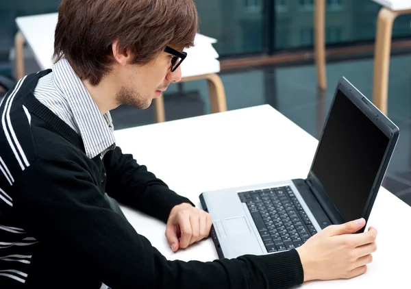 Vriendelijke uitvoerend zit laptop in zijn kantoor. — Stockfoto