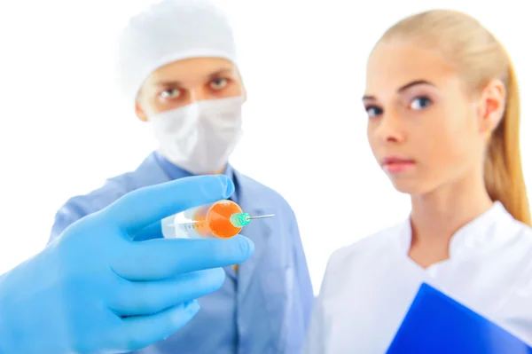 Retrato de médico sorridente com seu colega mostrando seringa com uma vacina — Fotografia de Stock