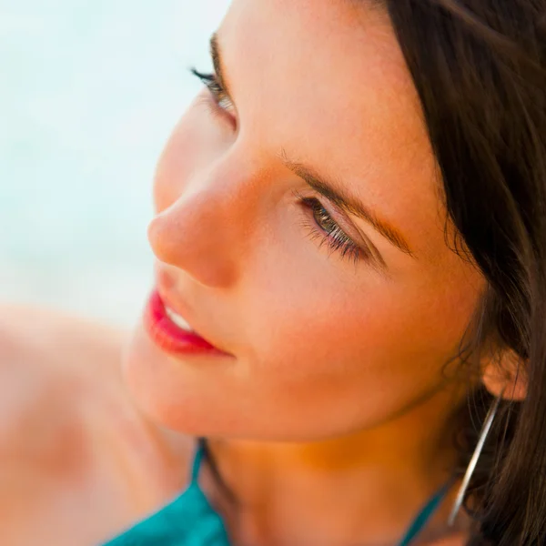 Красивая молодая женщина с горячим взглядом и сексуальной улыбкой сидит на пляже — стоковое фото