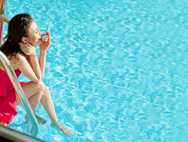 Beautiful natural woman smiling and eating dragon fruit at pool on summer vacations — Stock Photo, Image
