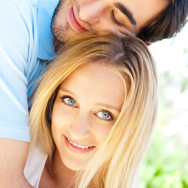 Retrato de casal de amor abraçando ao ar livre no parque olhando feliz — Fotografia de Stock