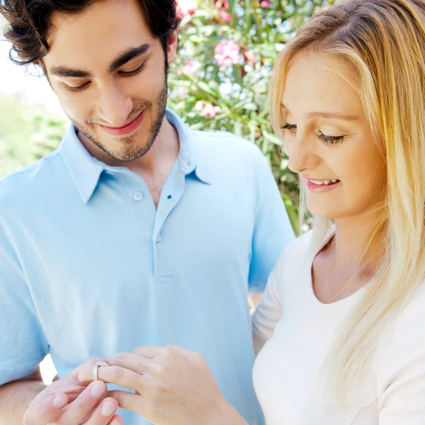 Feliz joven hispano regalando un anillo a una hermosa sorpresa —  Fotos de Stock