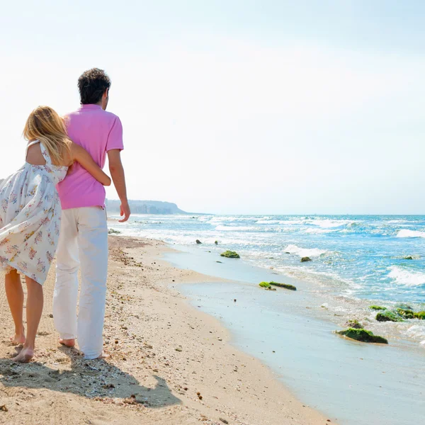 Couple à la plage tenant la main et marchant. Jour ensoleillé, lumineux — Photo