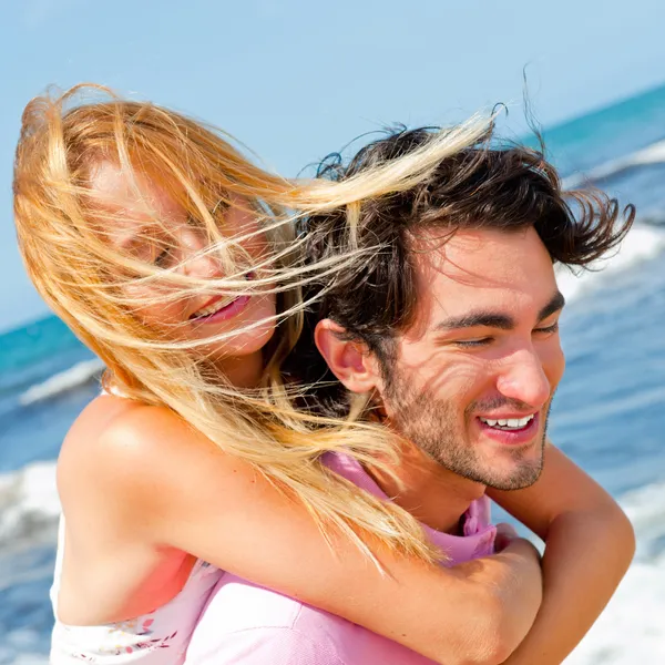 Um casal atraente brincando na praia — Fotografia de Stock