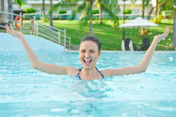 Donna in piscina si diverte con spruzzi — Foto Stock