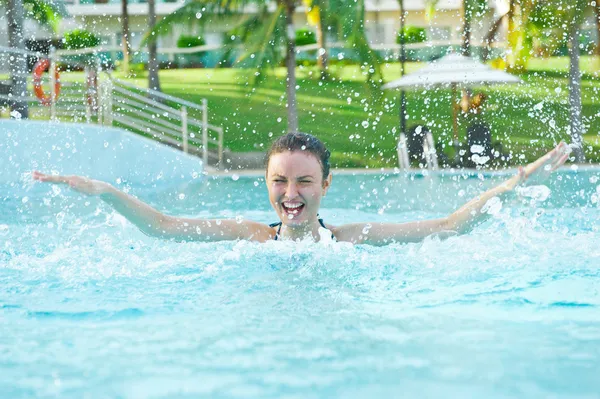 Frau im Pool hat Spaß mit Spritzwasser — Stockfoto