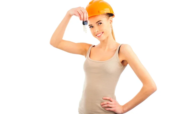 Foto de engenheiro de construção mulher feliz vestindo protetor capacete laranja segurando nova chave e olhando para a câmera . — Fotografia de Stock