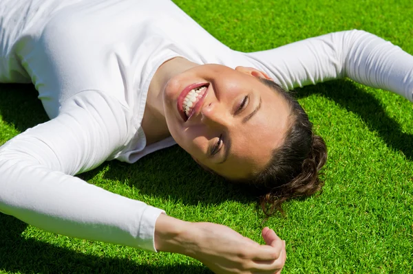 Kvinna avkopplande utomhus ser glad och ler — Stockfoto