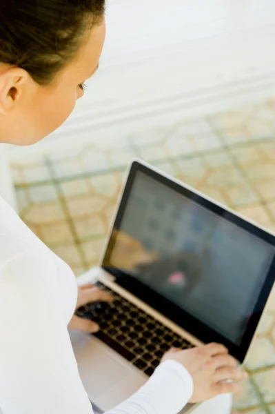 Üzletasszony ül a padon dolgozik laptop parkban, fehér ruhában — Stock Fotó