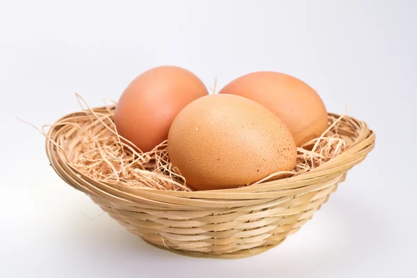 Három barna tojást, rattan kosár — Stock Fotó