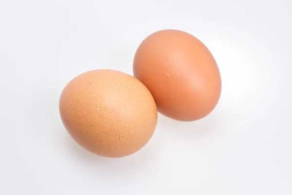Dvě hnědé vejce na bílém pozadí — Stock fotografie