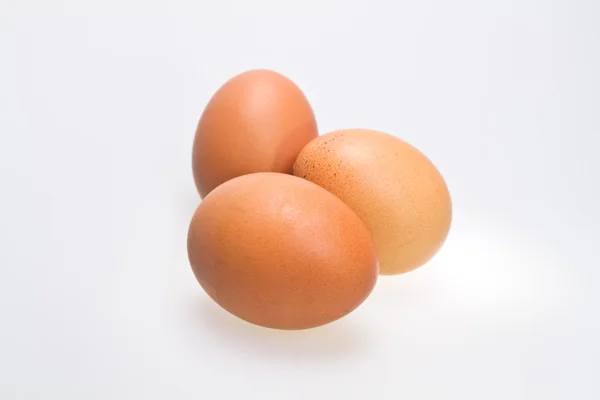 Три коричневі яйця на білому тлі — стокове фото