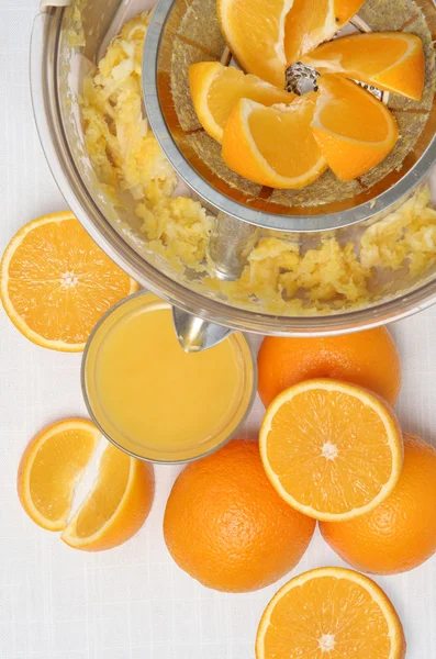 Frisch gepresster Orangensaft, Saftpresse und Orangen mit weißem Hintergrund. — Stockfoto
