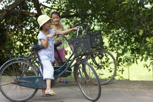 Vietnamese kinderen paardrijden fietsen Stockfoto