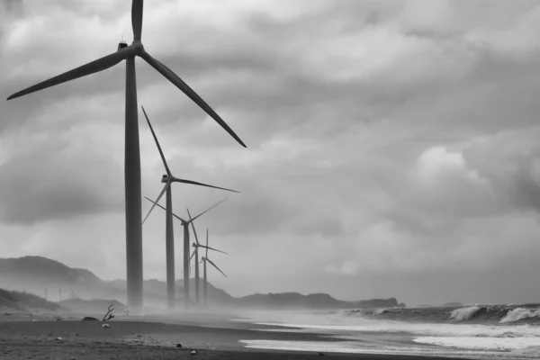 Turbinas eólicas en la playa frente al mar Fotos de stock