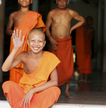 Cambodian Monk waves and smiles clipart