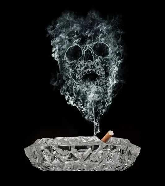 Smoke skull rising from a cigarette. — Stock Photo © Bombaert #9240859