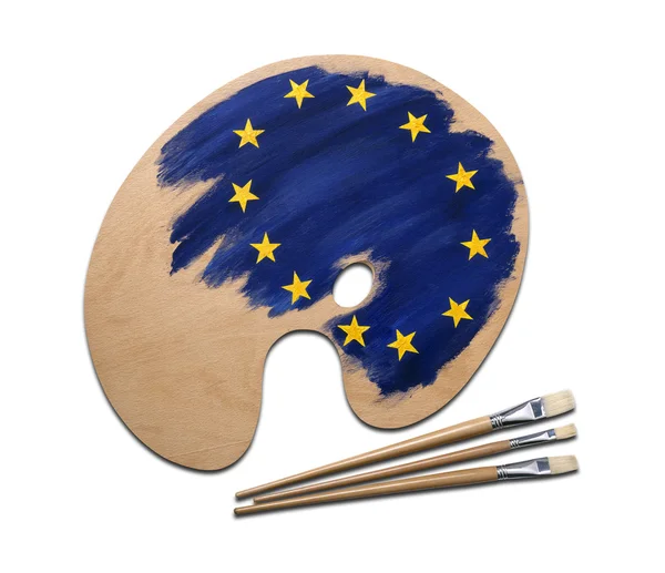 Палитра деревянных художников с европейскими красками и брусом под флагом — стоковое фото