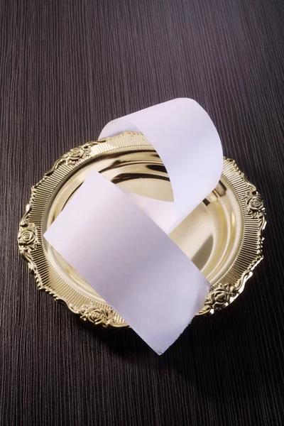 Papierrolle auf dem goldenen Teller — Stockfoto