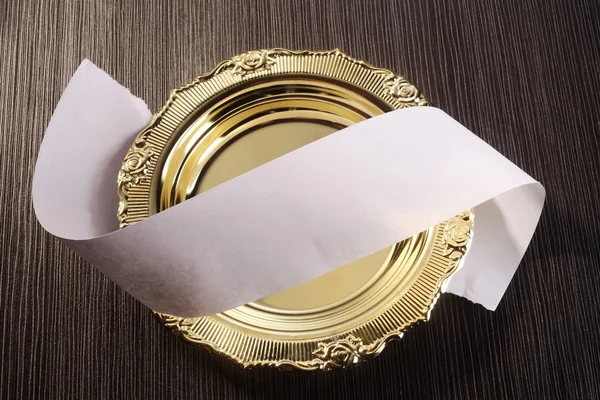 Roll of paper on the golden plate — Stock Photo, Image