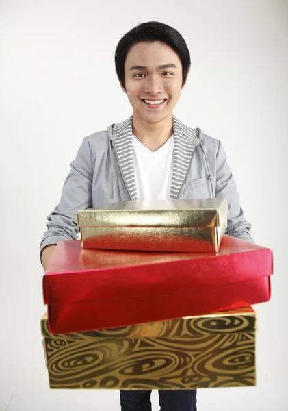 Mladý muž účetní kupu dárků, usměvavý, portrét — Stock fotografie