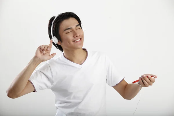 Genç adam bir akıllı telefon üzerinde müzik dinleme — Stok fotoğraf
