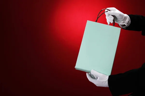 Beyaz eldiven giyen kapıcı holding alışveriş torbaları — Stok fotoğraf