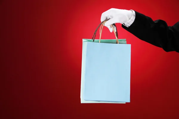 stock image Doorman wearing white gloves, holding shopping bags