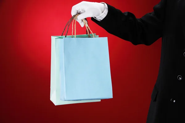 stock image Doorman wearing white gloves, holding shopping bags