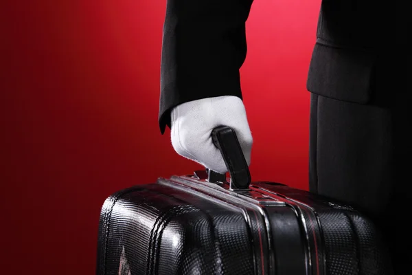 Портер готелю, що несе валізу, крупним планом, вид збоку — стокове фото