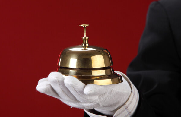 Man with hand glove holding a sercive bell