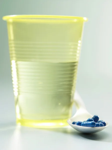 Colher de pílula e água — Fotografia de Stock