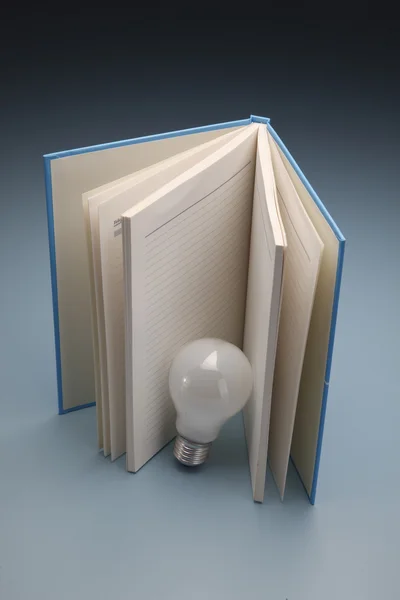 Um livro e uma lâmpada — Fotografia de Stock