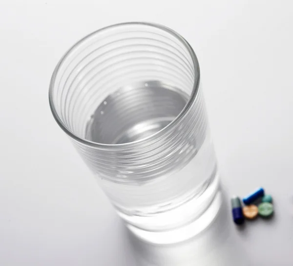 Таблетки і склянка води — стокове фото