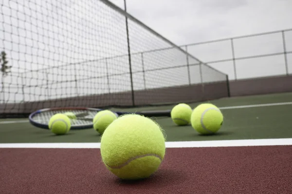 Piłki tenisowe i rakieta na sąd — Zdjęcie stockowe